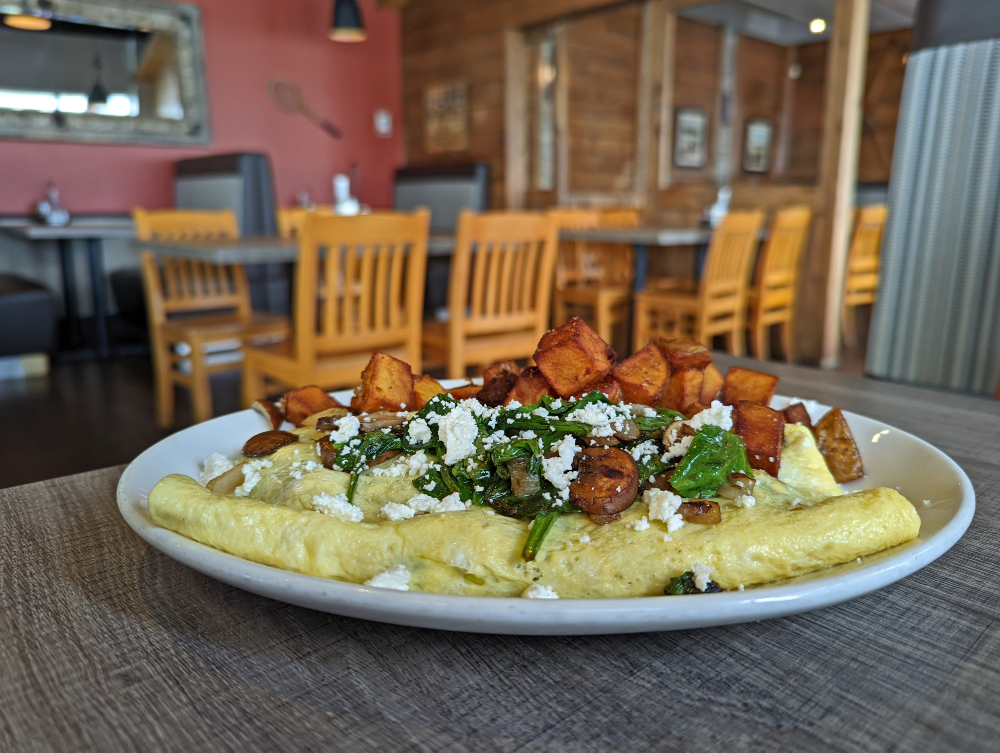 Cottage Canoe restaurant spinach omelette topped with home fries