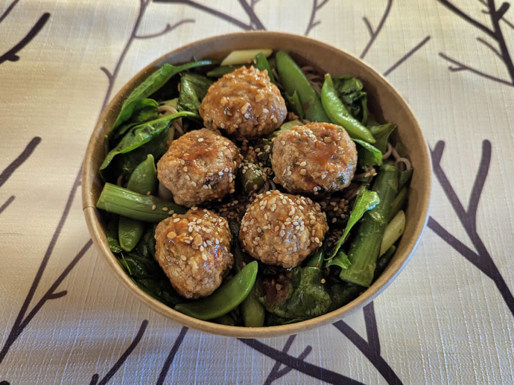 Five Meatballs on Top of Greens in a Brown Bowl from Prepped Manitoulin